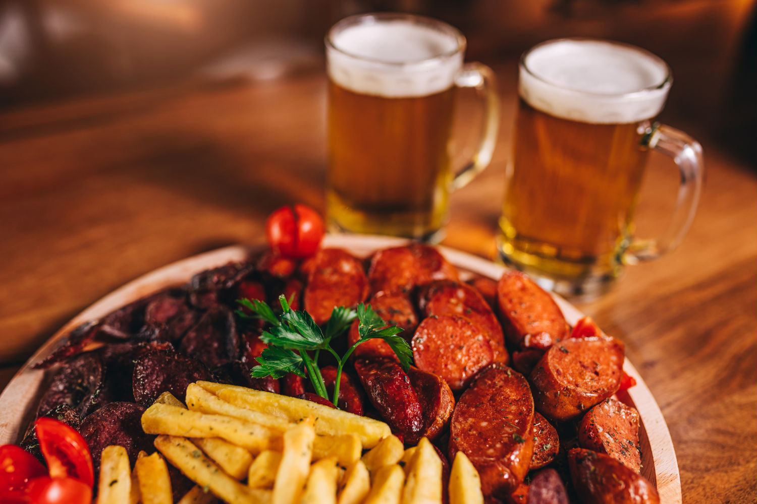 Pub food platter with fries, sausages, meat and beers in the back | Bala Bay Inn Eats