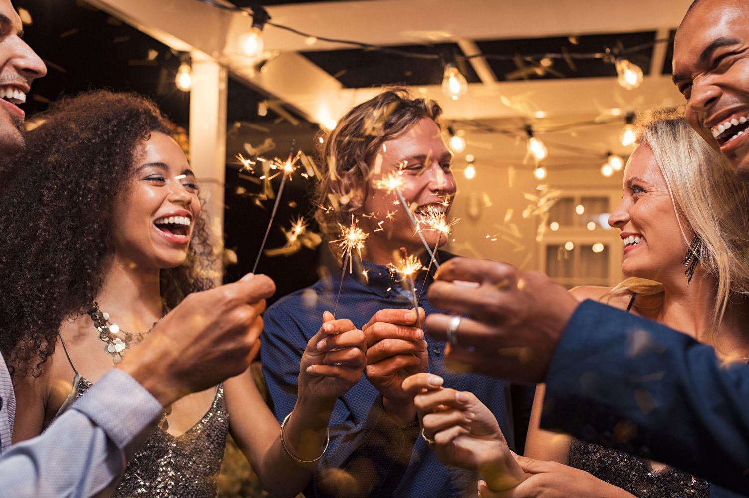 A group of friends having a blast with sparklers and drinks at a New Year's Eve party | Bala Bay Inn