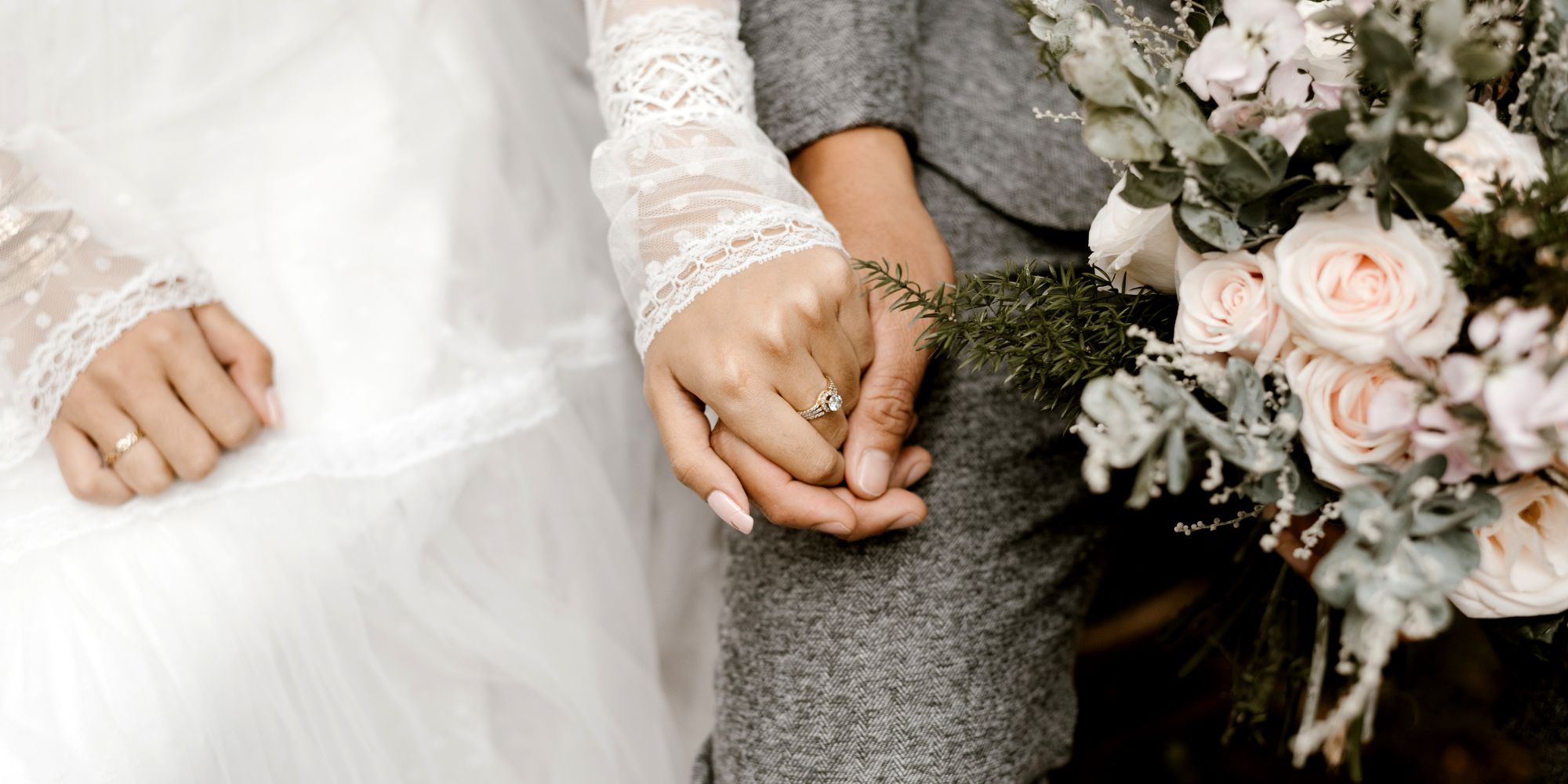 Happy couple at their wedding holding hands close up of rings and flowers | Bala Bay Inn Weddings