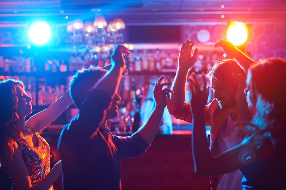 Dark lit club scene with people dancing